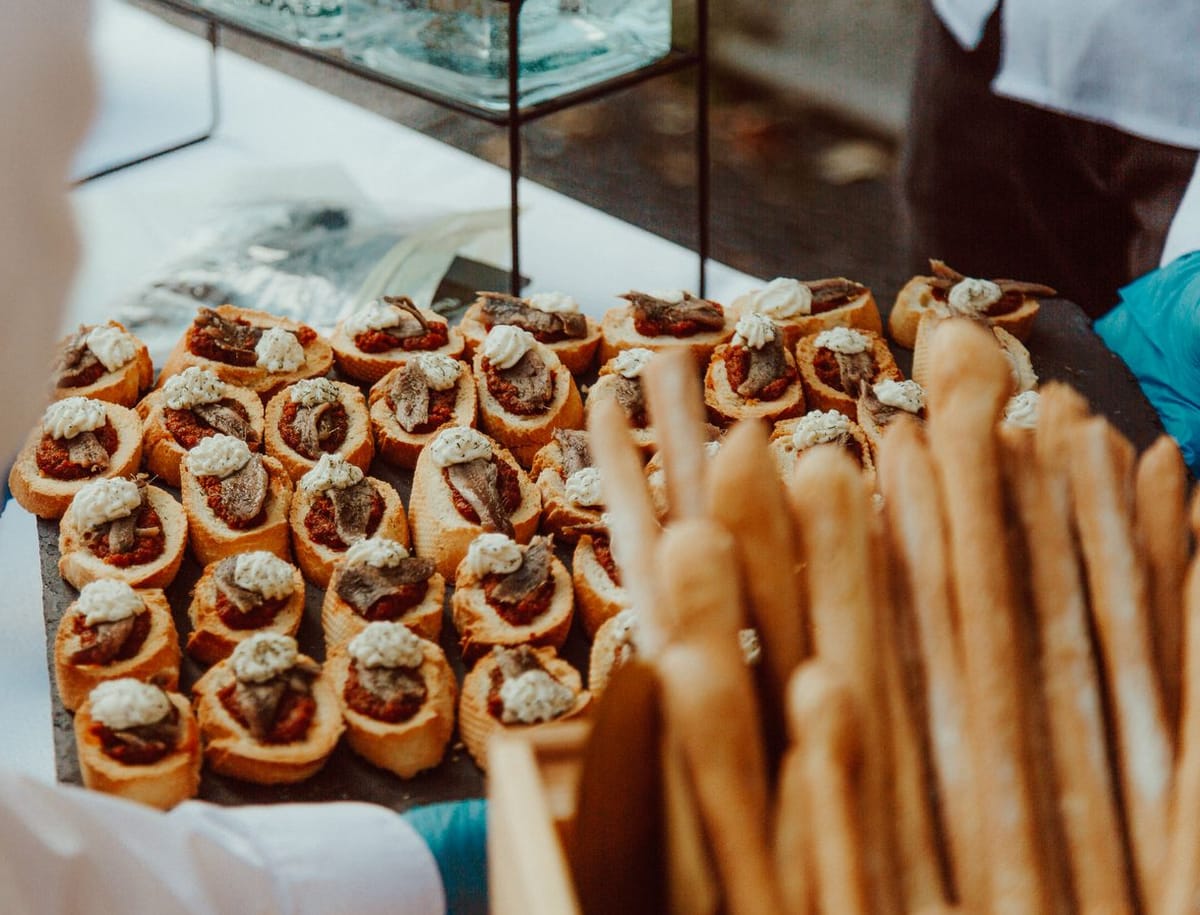 Um empregado a apresentar uma bandeja de canapés num evento de catering (fotografia ilustrativa de banco de imagens)